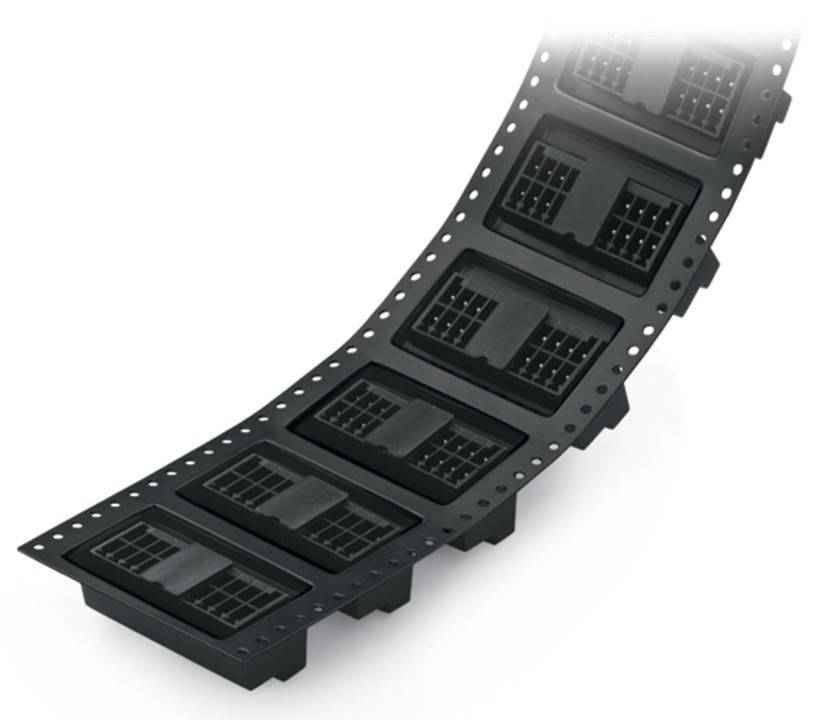 Schwarze Kunststoff-Elektronikverbinder, die in einem geschwungenen Streifen angeordnet sind, möglicherweise für Fertigungs- oder Montagezwecke.