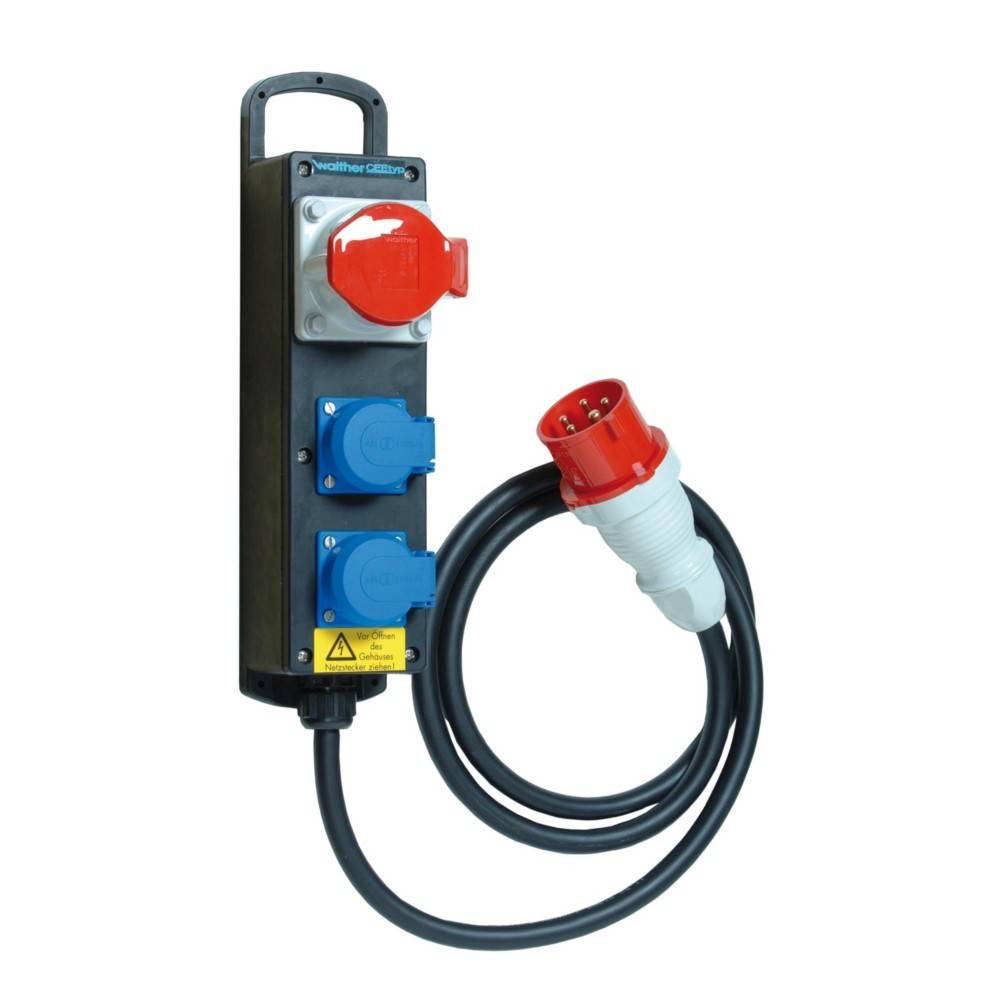 Eine schwarze Stromverteilungseinheit mit einem roten industriellen Stecker, drei blauen Steckdosen und einem schwarzen Griff. Ein gelbes Warnschild ist sichtbar.