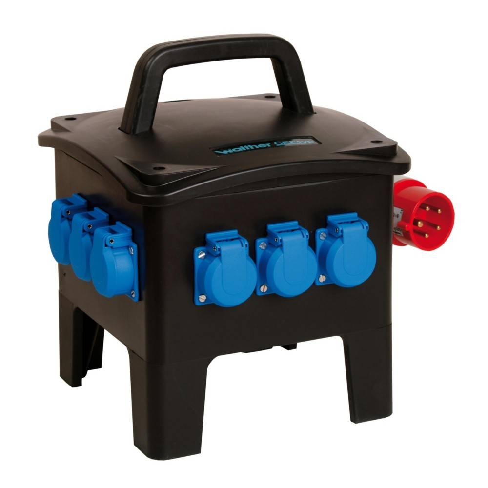 Eine schwarze mobile Stromverteilungsbox mit blauen Steckdosen und einem roten Stecker, die für elektrische Anschlüsse auf Baustellen oder bei Veranstaltungen verwendet wird.