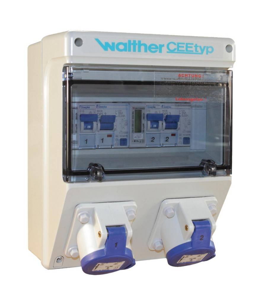 Industrieller elektrischer Stromverteilungskasten mit transparentem Deckel, auf dem Sicherungsautomaten mit den Bezeichnungen '1' und '2' zu sehen sind, zwei Steckdosen darunter.