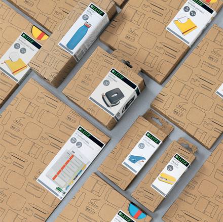 Assortierte Kartonproduktboxen mit illustrierten Etiketten, einschließlich einer Wasserflasche, eines Hefters, eines Bügeleisens und eines Kleidungsbügeleisens, angeordnet auf einer grauen Oberfläche.