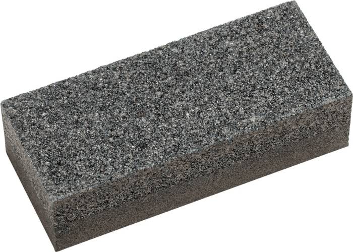 Ein Nahaufnahmebild eines grauen rechteckigen Bimssteins, das seine raue und poröse Textur zeigt, die typischerweise zum Entfernen toter Hautschüppchen verwendet wird.