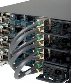 Rückansicht eines Serverracks mit mehreren schwarzen Netzwerkservern, die durch dicke graue und blaue Ethernet-Kabel verbunden sind.