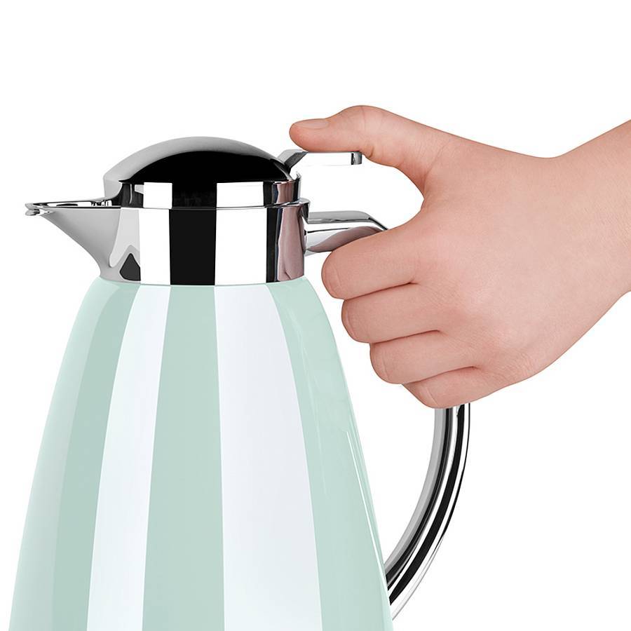 Hand drückt den Griff eines Edelstahl-Thermobehälters mit mintgrünem Körper auf weißem Hintergrund.