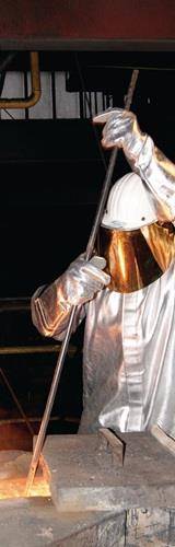 Eine Person, die einen reflektierenden Schutzanzug und einen Helm trägt, benutzt ein Werkzeug und deutet damit auf eine Szene mit industrieller oder Notfallarbeit hin.