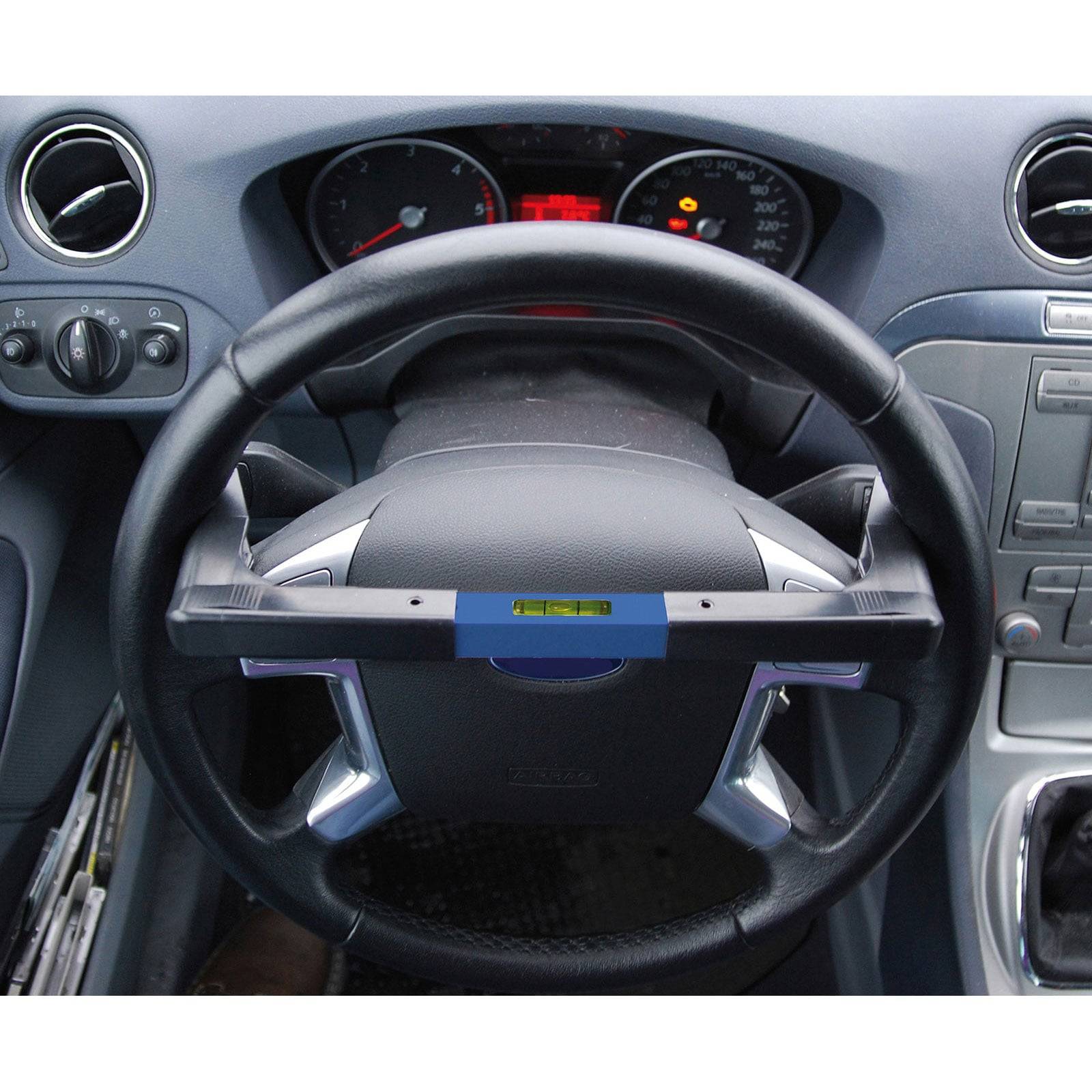 Lenkrad eines Fahrzeugs mit einem blauen Wasserwaage-Werkzeug, das zeigt, dass das Rad ausgewuchtet ist. Armaturenbrett-Instrumente sind im Hintergrund sichtbar.