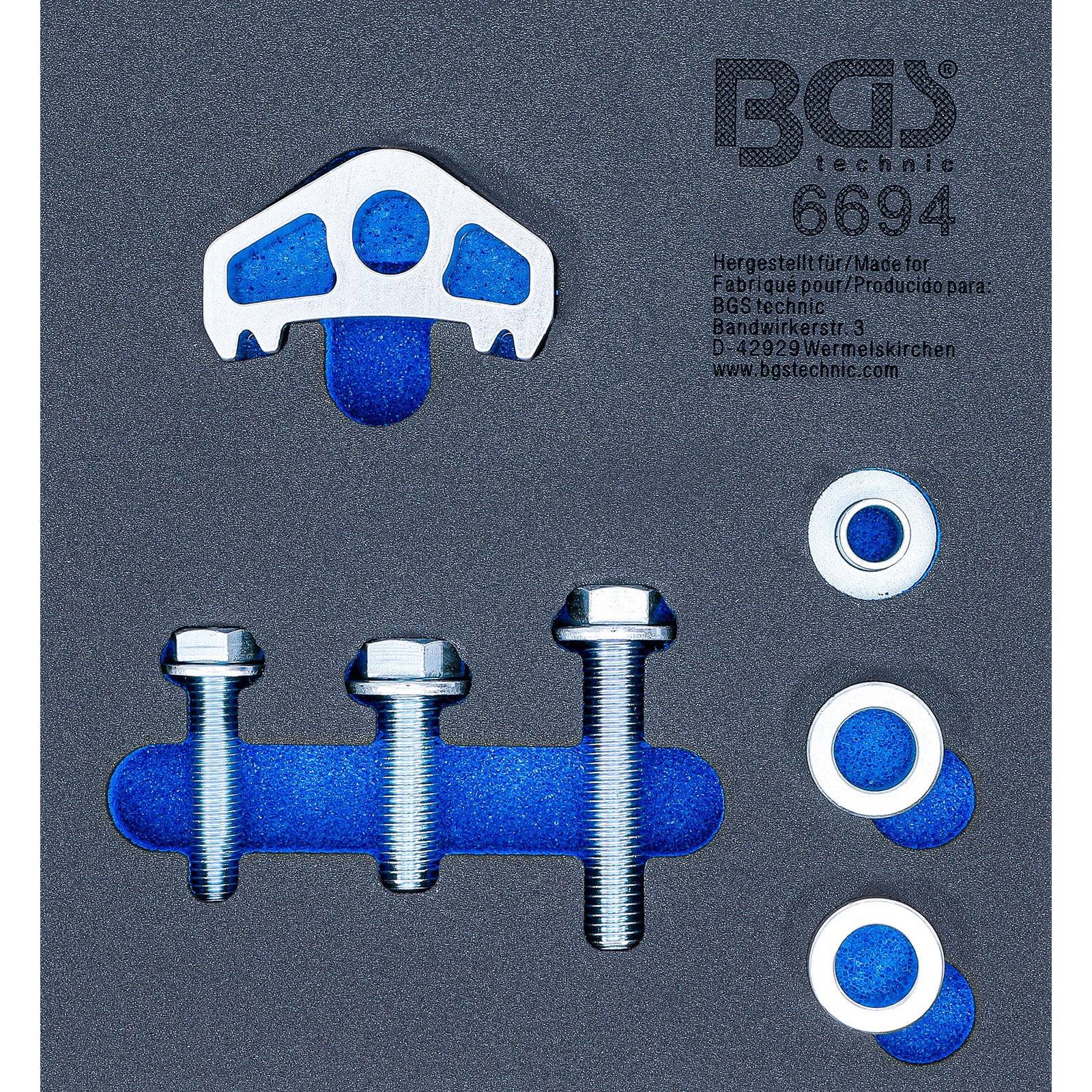 Das Bild zeigt einen BGS Technic 6094 Bremssattel-Werkzeugsatz mit Schrauben und Unterlegscheiben auf einem dunkelgrauen Schaumstoffeinsatz.