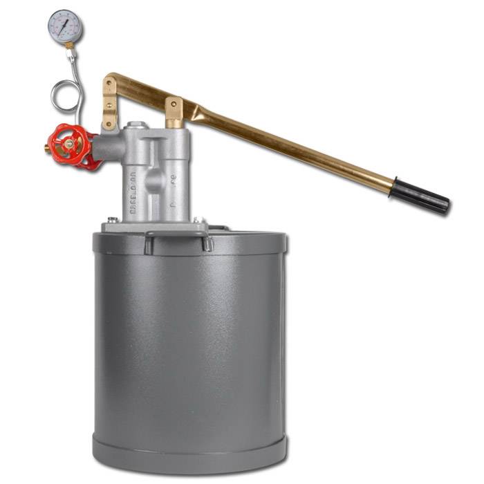 Manuelle Hydraulikpumpe mit Manometer, rotem Ventilrad und langem Hebel auf einem grauen Speichertank montiert.