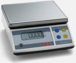 Eine digitale Küchenwaage zeigt '0,000 g' auf ihrem Display, mit Tasten für Tara, Maßeinheitenumwandlung und Ein/Aus-Funktion auf einer metallfarbenen Oberfläche.