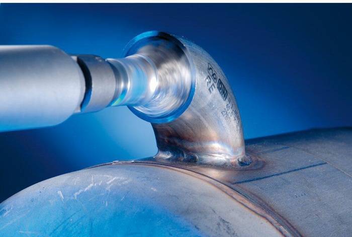 Eine Metallröhre, die von einer Maschine poliert wird, mit einer Nahaufnahme des Vorgangs und Fokus auf die Rotation und den Glanz der Metalloberfläche.