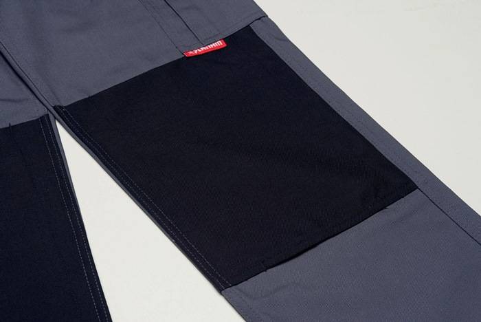 Nahaufnahme schwarzer und grauer Hose mit breitem elastischem Bund und Reißverschlusstaschenelement.