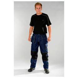 Eine Person steht selbstbewusst in einem schwarzen Shirt und dunkler Utility-Hose mit Knieschonern vor einem einfachen Hintergrund.