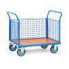 Ein blauer Metallwagen mit einer flachen Holzfläche und Gitterseiten, der zum Transport von Waren verwendet wird, auf vier Rädern.