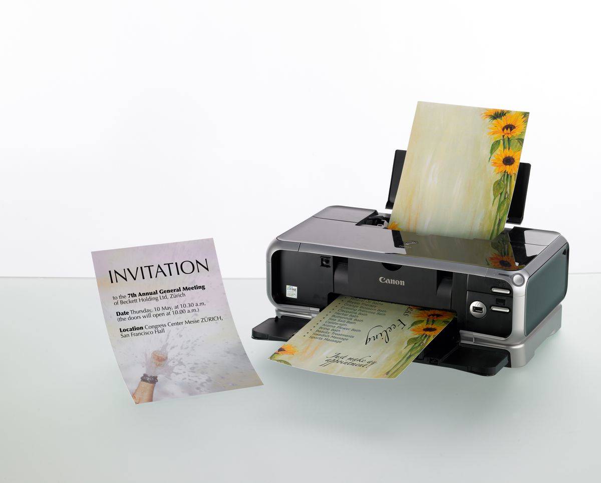 Canon-Drucker druckt farbenfrohe Einladungskarten, wobei eine fertiggestellte Einladung neben der Maschine steht.