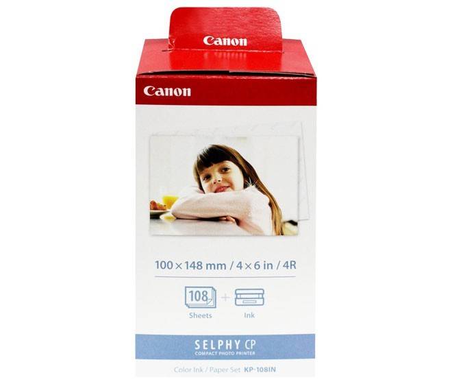 Eine rote und weiße Box für einen Canon Selphy CP Kompakt-Fotodrucker enthält Tinte und Papier für 108 Fotos, mit einem lächelnden Kind auf der Vorderseite.