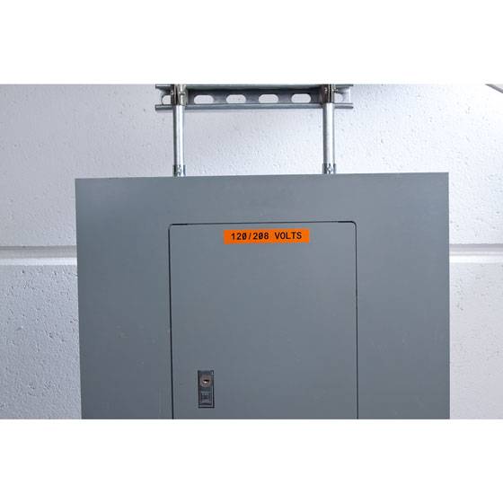Grauer Schaltschrank an einer Wand mit einem orangefarbenen Etikett mit der Aufschrift „120/208 VOLTS