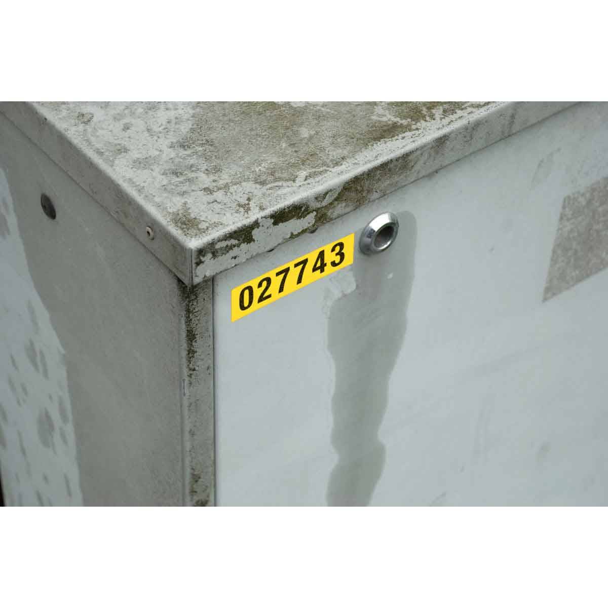 Nahaufnahme einer abgenutzten grauen Metallverteilerkasse mit einem gelben Etikett mit der Aufschrift 