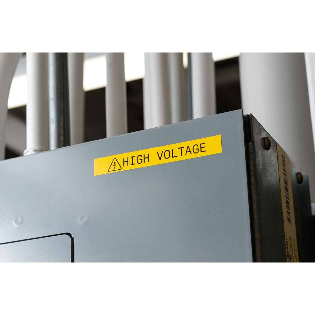 Nahaufnahme eines grauen Elektroschaltkastens mit einem gelben Warnschild „HOCHSPANNUNG