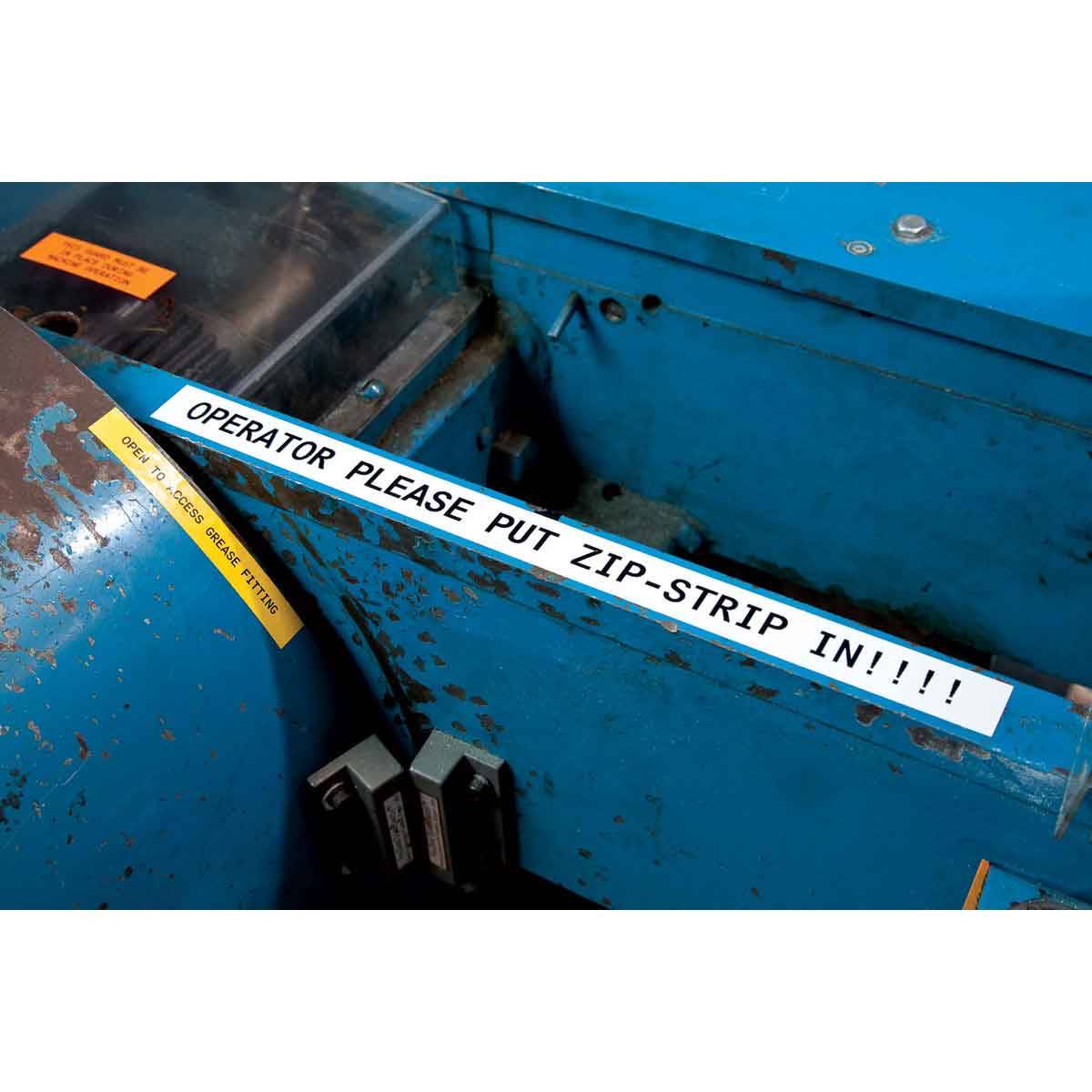 Nahaufnahme einer blauen Industriemaschine mit einem Warnstreifen, der 