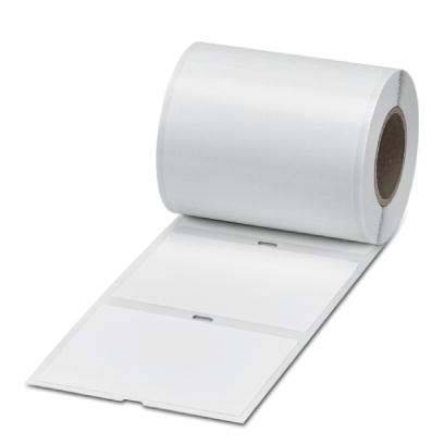 Eine Rolle von leeren Klebeetiketten, die sich abwickelt und zwei rechteckige Aufkleber mit einer Trennlinie auf einer flachen Oberfläche zeigt.