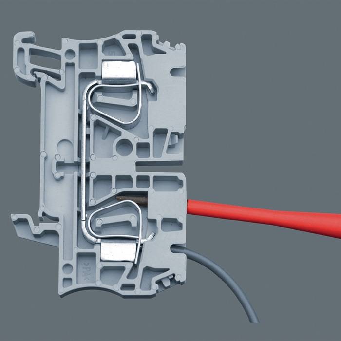 Querschnitt eines grauen Kunststoff-Elektroverbinders mit Metallklammern, der rote und graue Kabel zeigt, die sicher im Mechanismus befestigt sind.
