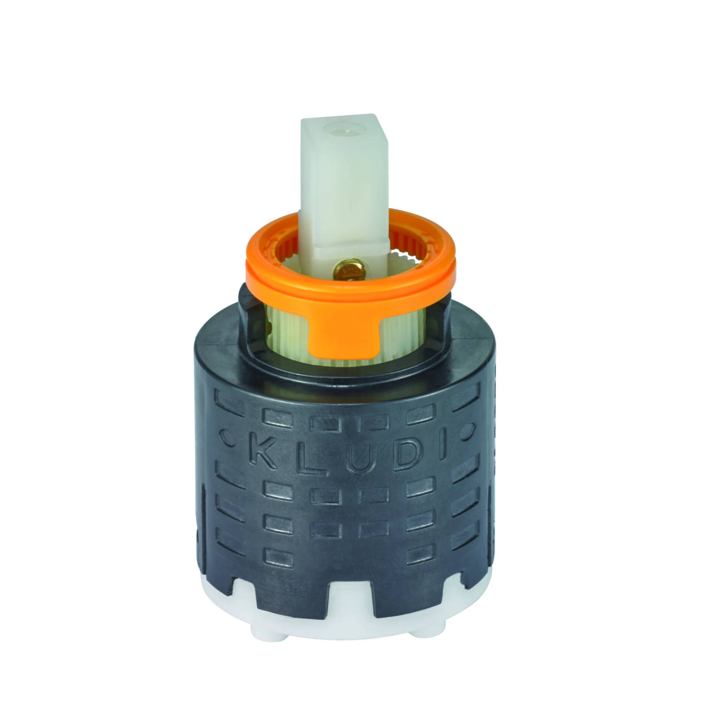 Eine kleine Sanitär-Armaturenpatrone mit dunkelgrauem zylindrischem Gehäuse, orangefarbenem Ring und durchscheinendem oberem Schaft auf weißem Hintergrund.