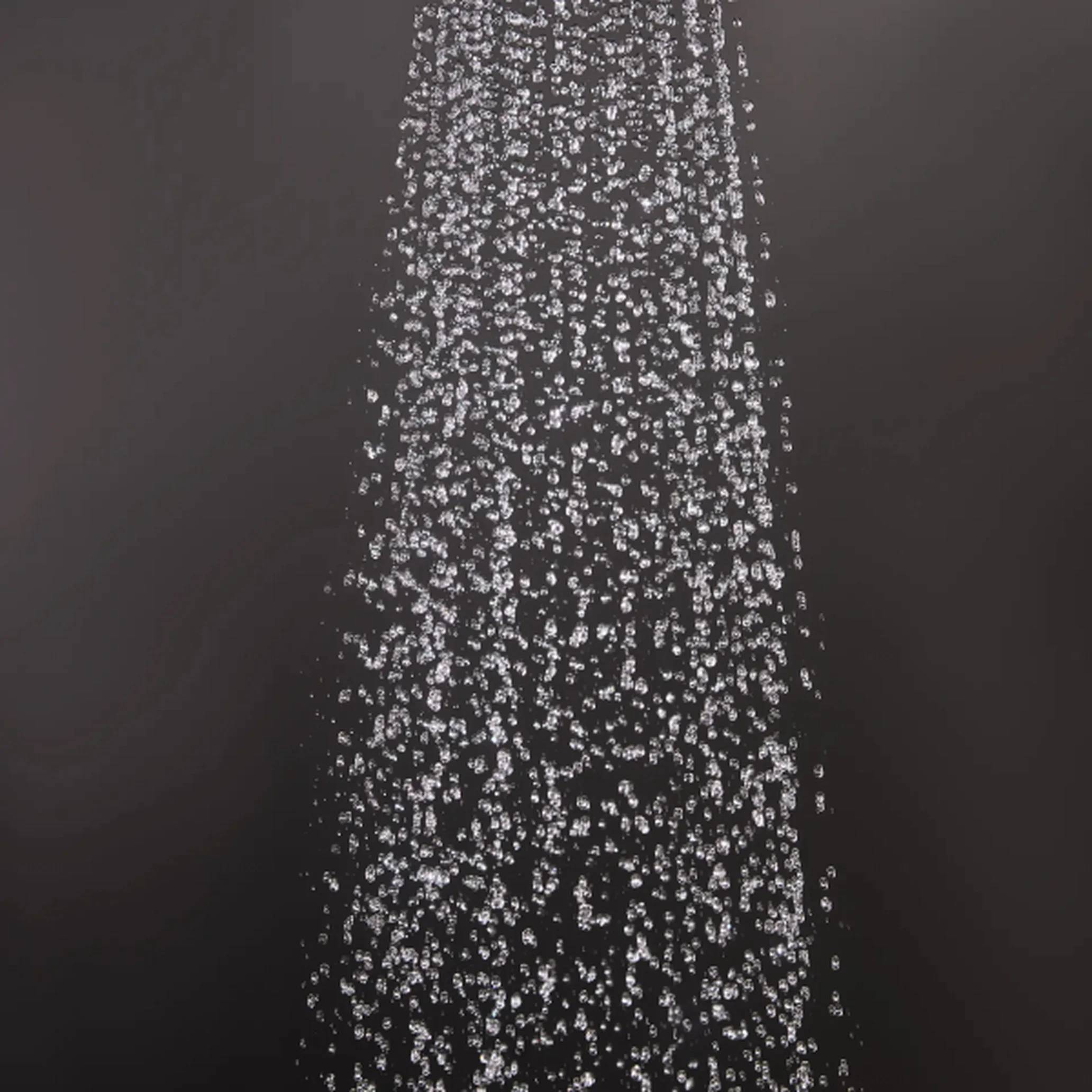 Dichte Säule aus funkelnden Wassertropfen oder Blasen, die vertikal gegen einen dunklen Hintergrund fallen, wie ein Springbrunnenschaum oder Duschstrahl.