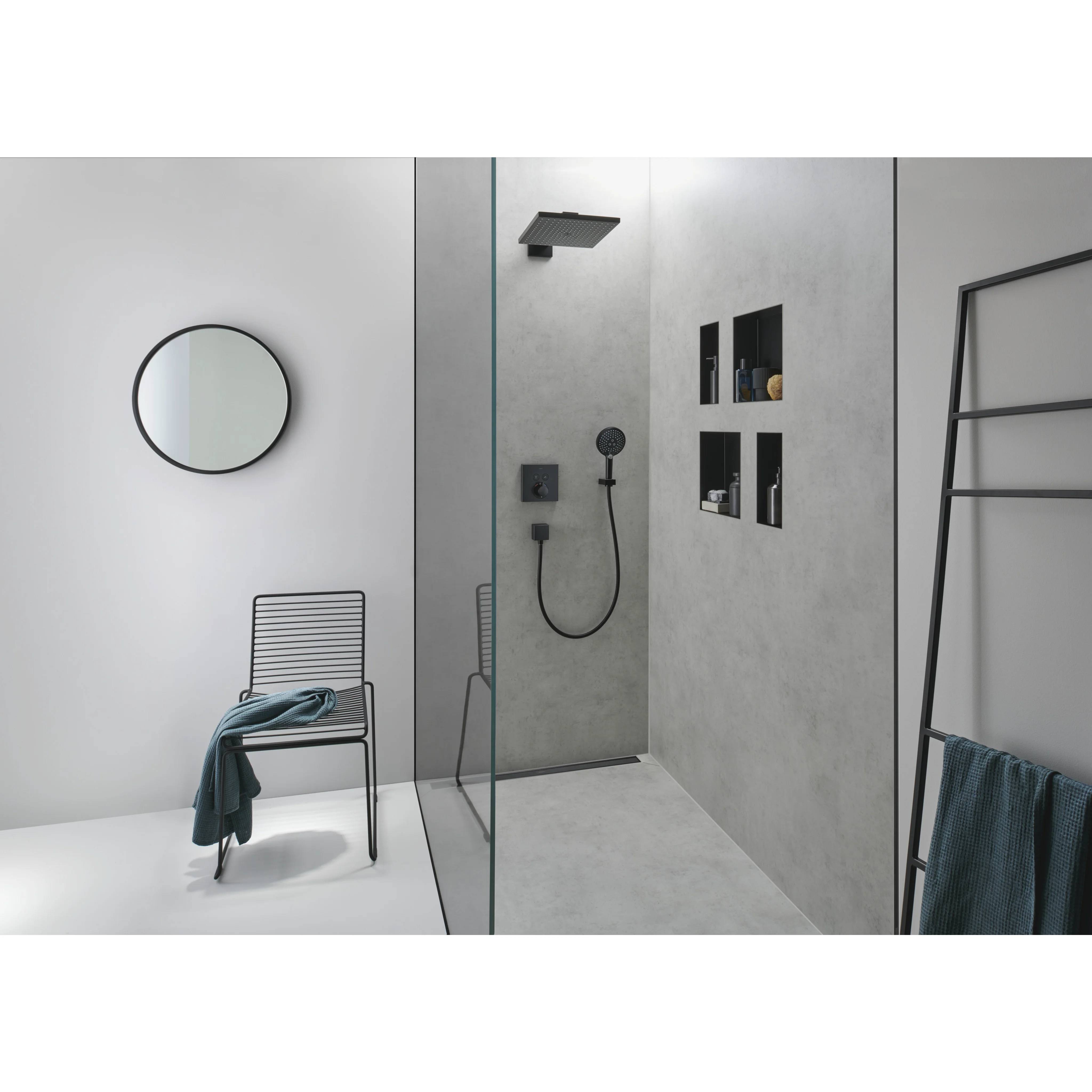 Minimales modernes Badezimmer mit begehbarer Dusche, rundem Spiegel, Stuhl mit Handtuch und Leiter-Handtuchhalter.