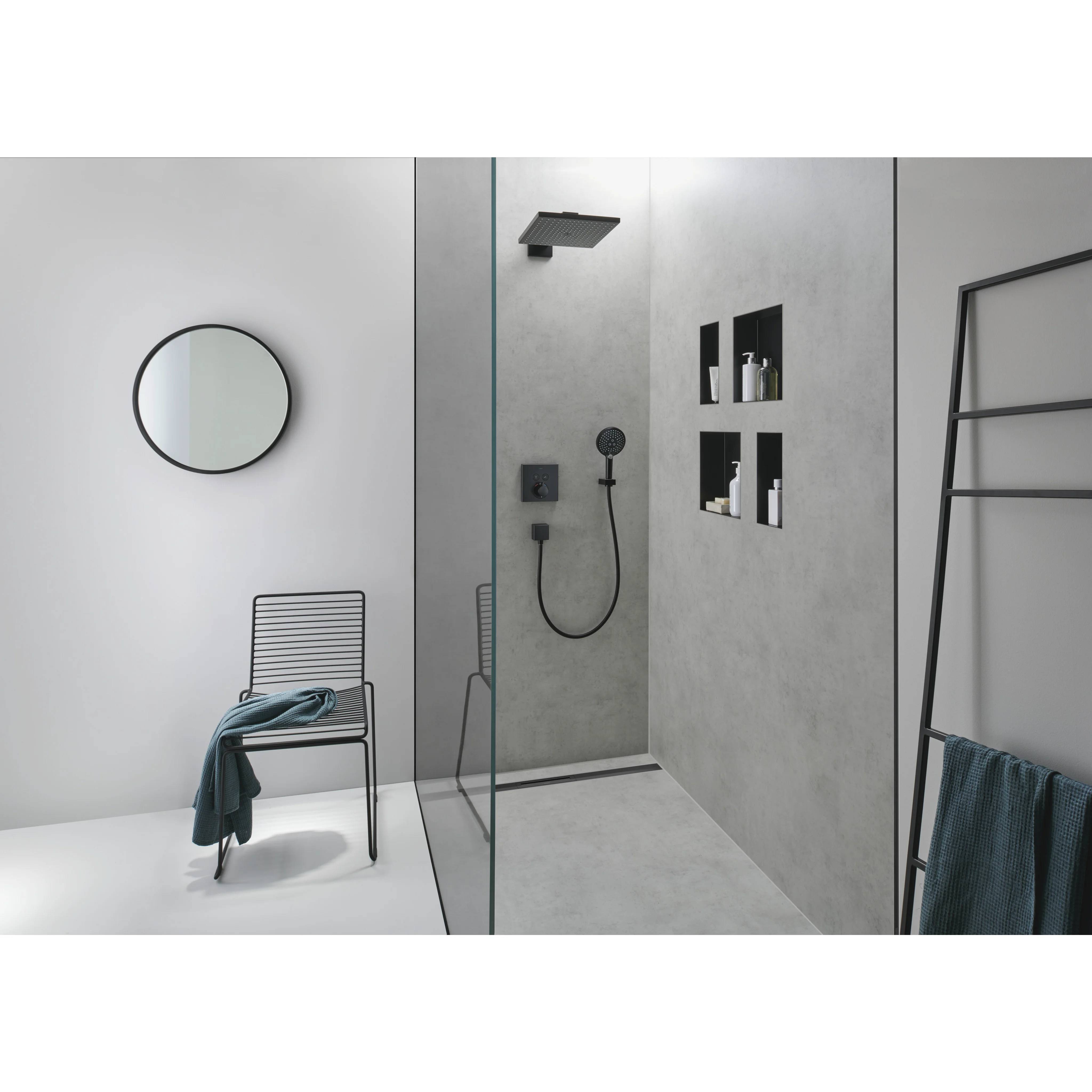 Modernes minimalistisches Badezimmer mit einer Glasdusche, schwarzen Armaturen, Wandnischen, rundem Spiegel und einem Stuhl mit Handtuch.