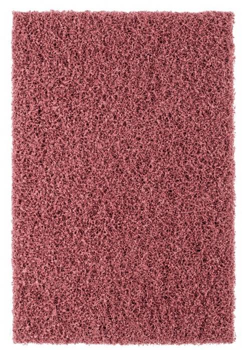 Eine Nahaufnahme eines texturierten, rosa Scheuerpads, die dessen poröse und raue Oberflächenstruktur detailliert zeigt.