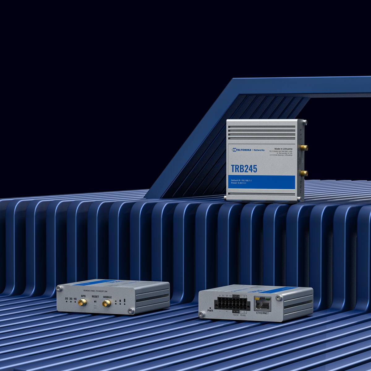 Drei industrielle Kommunikationsgeräte auf einer gerippten Oberfläche: eines mit Antennenbuchsen, eines mit Netzwerk-Anschlüssen und „TRB245
