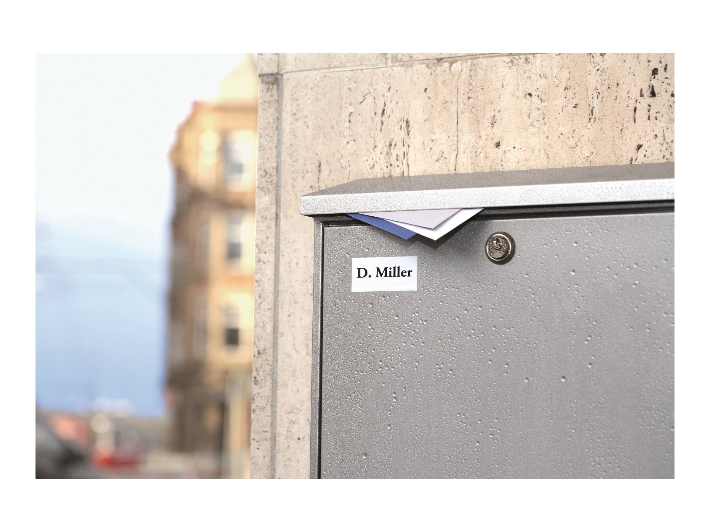 Grauer Außenbriekasten oder Versorgungskasten an einer Wand montiert, mit der Aufschrift „D. Miller