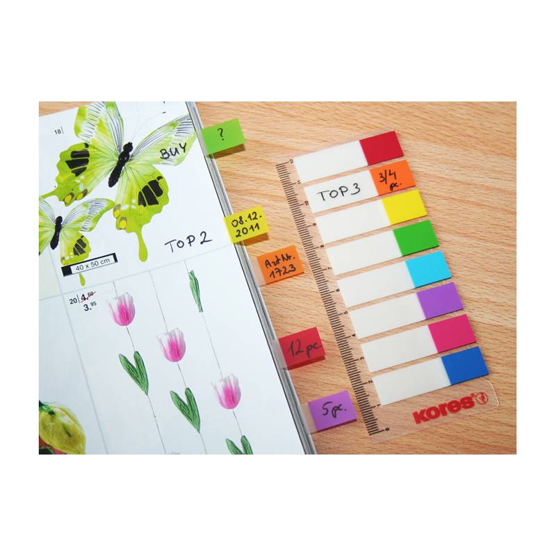 Ein Planer mit Schmetterlings- und Tulpenillustrationen, Haftnotizen mit den Markierungen '2021', '4. Apr', 'Montag' und ein buntes Lineal mit beschrifteten Fächern.