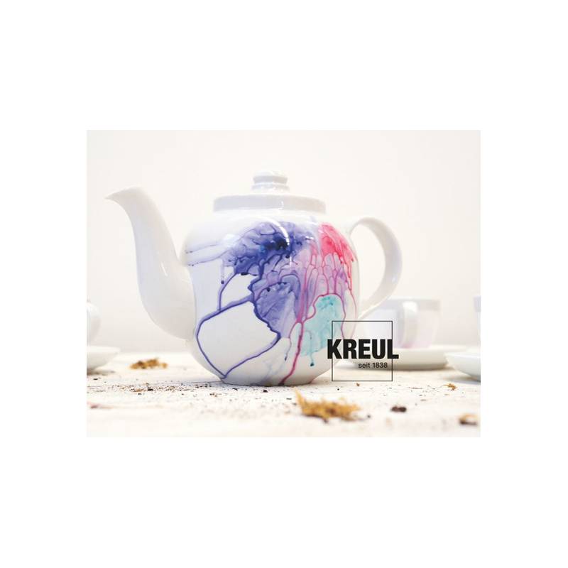 Ein weißer Teekanne mit bunten Farbspritzern in Blau, Lila und Rosa. Ein Logo der Marke 'Kreul' ist an der Seite sichtbar.