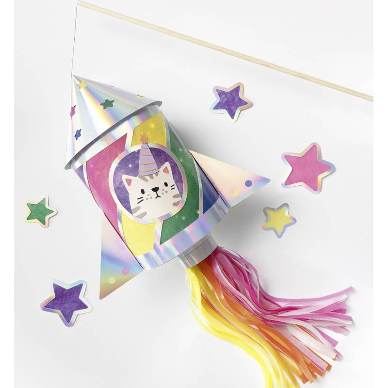 Eine bunte Papierrakete mit einer Katzenillustration in der Mitte. Die Rakete hat ein Regenbogendesign und Streifen in Rosa, Gelb und Weiß.
