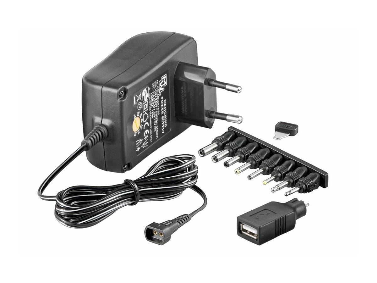 Schwarzer Wechselstromadapter mit Spiralkabel, austauschbaren Steckerspitzen und USB-Portadapter auf weißem Hintergrund gezeigt.