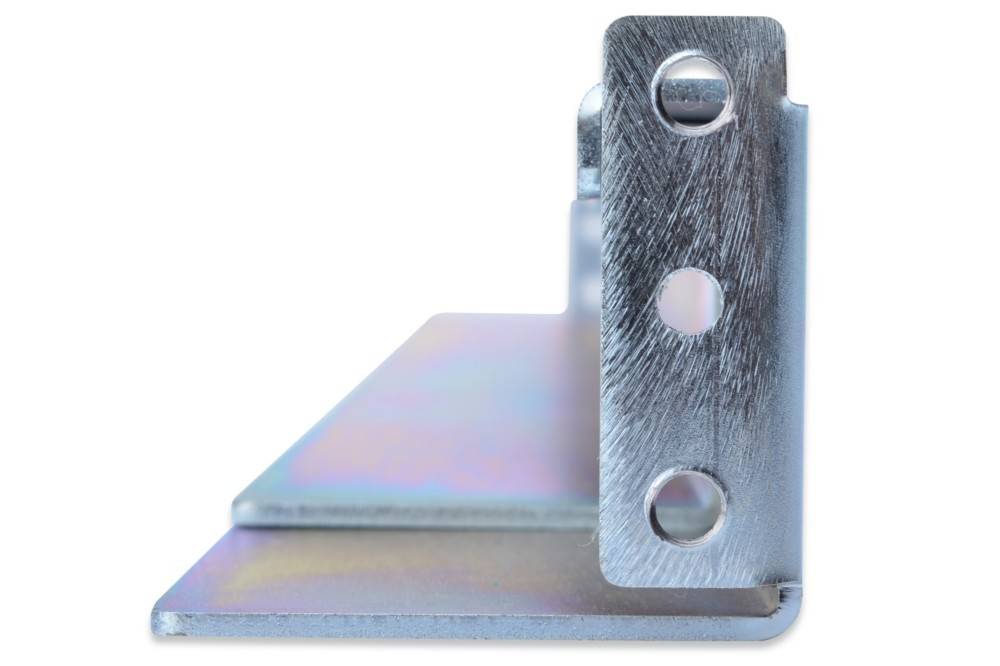 Eine Nahaufnahme einer metallfarbenen L-Schiene mit drei kreisrunden Löchern, wahrscheinlich zur strukturellen Unterstützung oder zum Verbinden von Materialien verwendet.