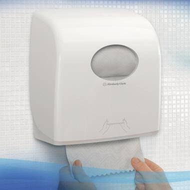 Wandmontierter weißer Papierhandtuchspender mit einem herausgezogenen Handtuch