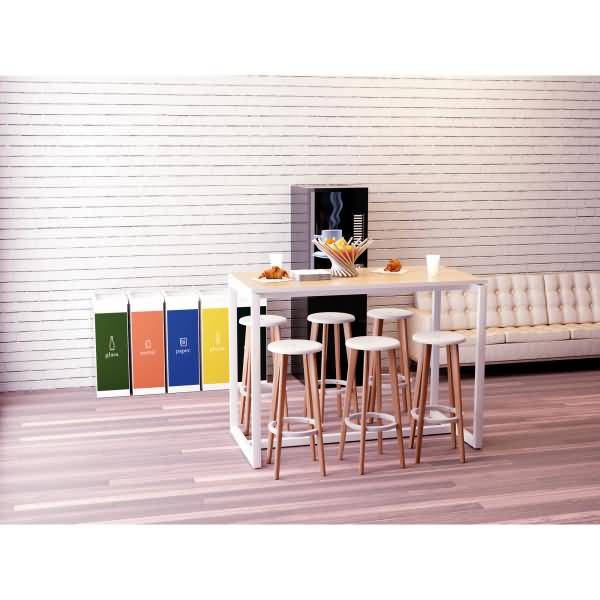 Moderne Küchenausstattung mit weißem Inselstisch und Hockern, Lebensmittel und Getränke oben drauf, farbenfrohe Behälterpanele daneben und ein Sofa im Hintergrund.