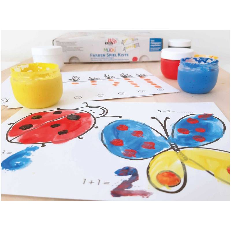 Ein Tisch mit Gläsern voller bunter Farben und Arbeitsblättern, die bemalte Zahlen und Tiere zeigen, einschließlich eines Marienkäfer- und Schmetterlingsdesigns.