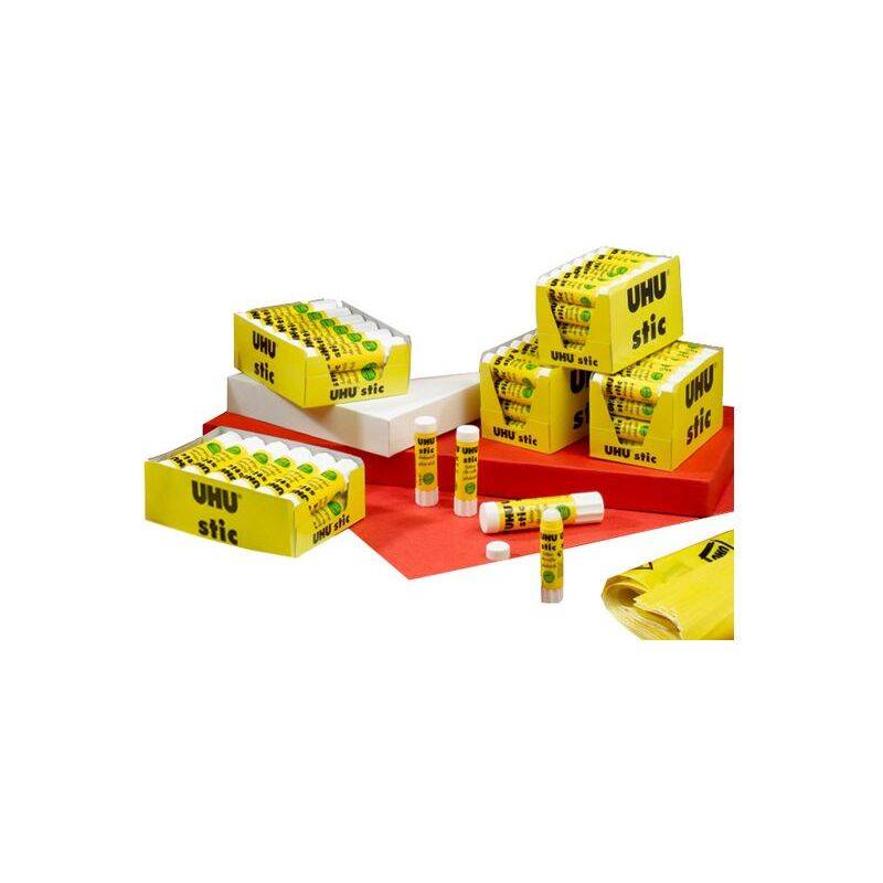 Schachteln und Röhren von UHU stic Kleber, die auf roten und weißen Oberflächen präsentiert werden und die gelbe Verpackung und das Markenlogo des Produkts hervorheben.