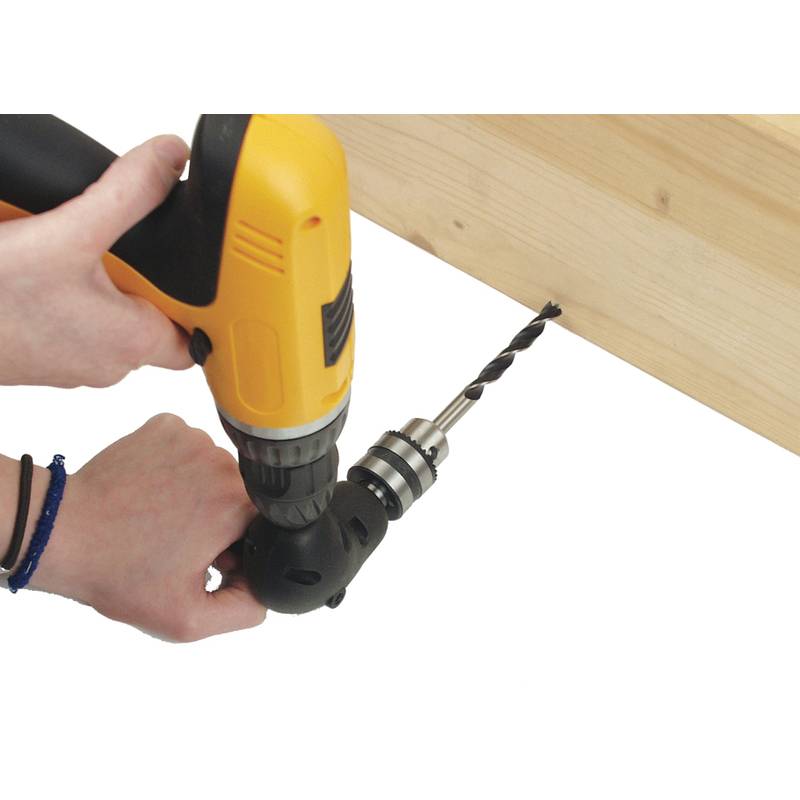 Eine Person, die mit einem gelben Bohrer ein Loch in eine leichte Holzoberfläche bohrt und dabei eine Zimmermanns- oder Heimwerkeraktivität demonstriert.