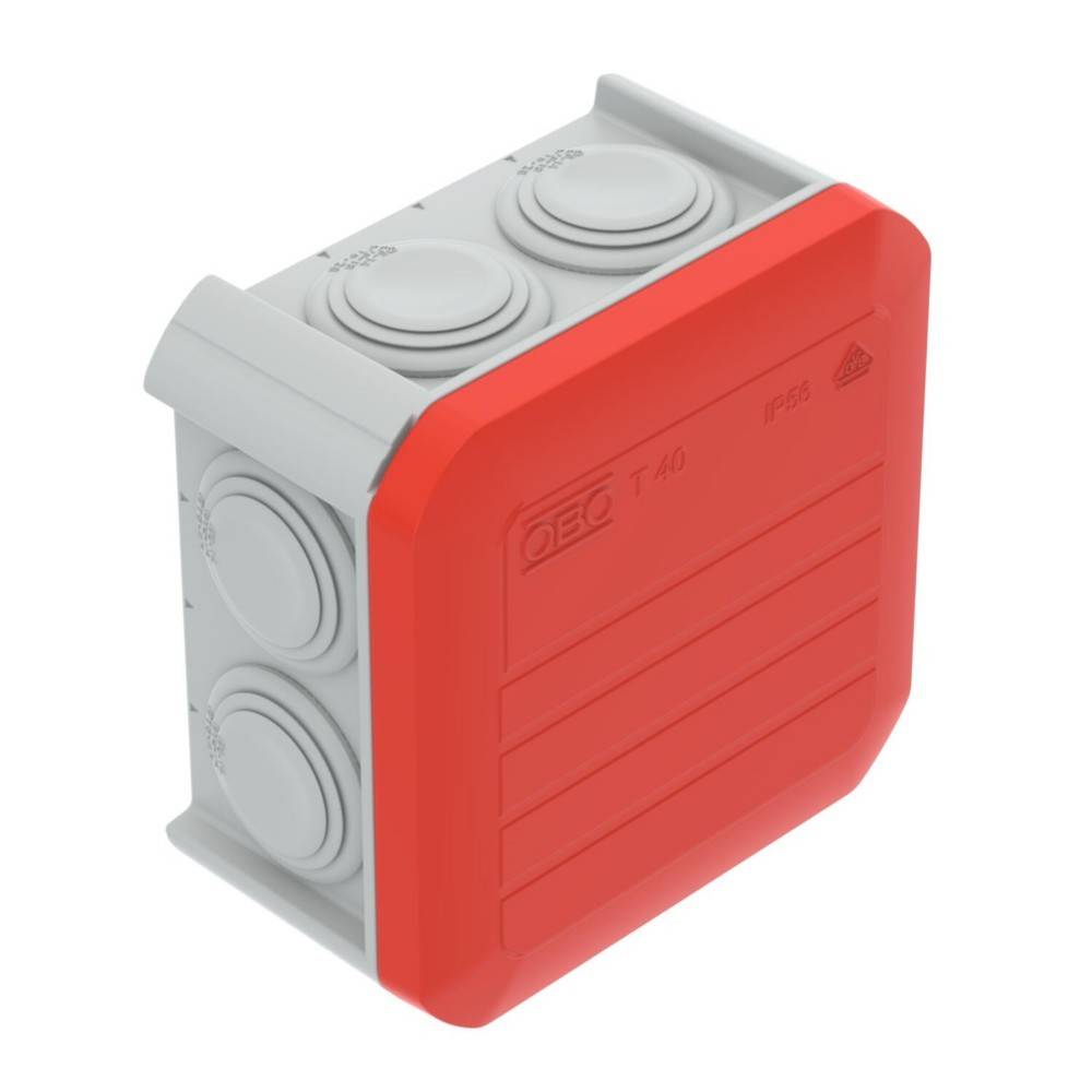 Eine rote und graue Kunststoff-Elektroverteilerdose mit mehreren runden Ausbrechöffnungen für Kabeleinführungen und einer beschrifteten Abdeckung oben.