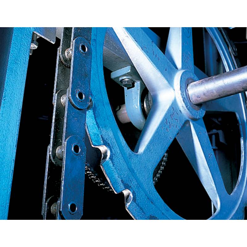 Eine Nahaufnahme von Industriemaschinen mit Fokus auf einer großen metallisch blauen Zahnrad- und Schraubenkonfiguration, die eine mechanische Funktion veranschaulicht.