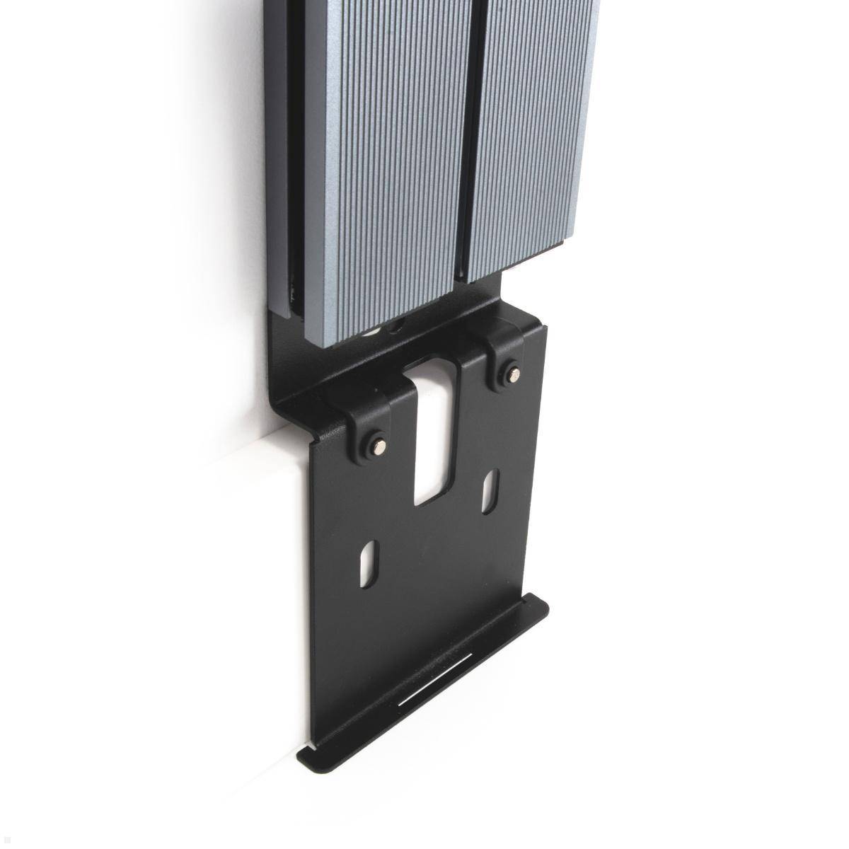 Eine wandmontierte Halterung, die eine rechteckige elektronische Vorrichtung mit strukturierter Oberfläche trägt.