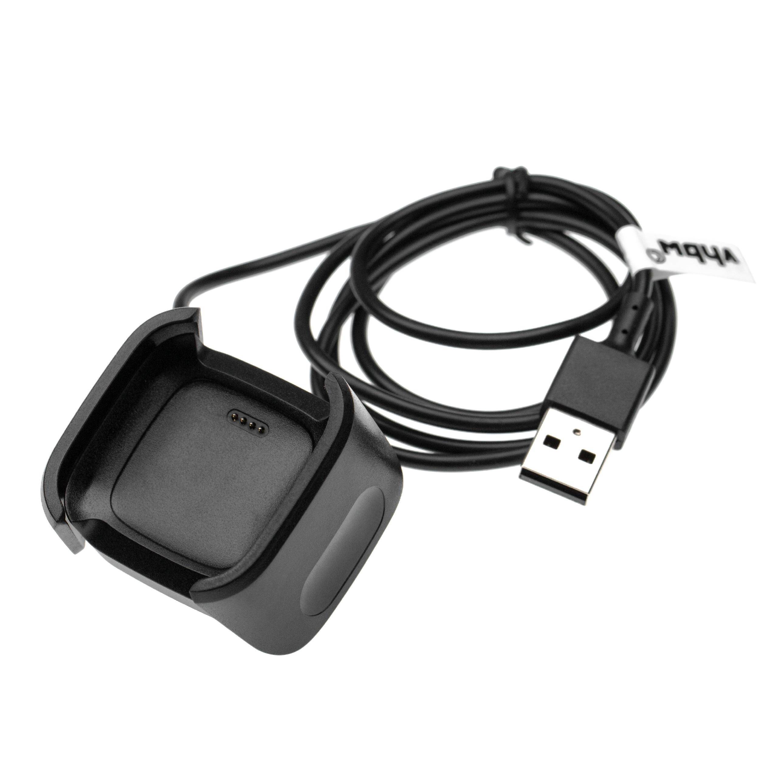 Schwarze USB-Ladestation mit angeschlossenem Kabel für ein kleines tragbares Gerät oder eine Smartwatch, gezeigt auf weißem Hintergrund.