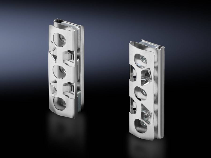 Zwei Edelstahlmaschinenkomponenten mit kreisförmigen Ausschnitten und gravierten Details stehen vor einem dunkel verlaufenden Hintergrund.