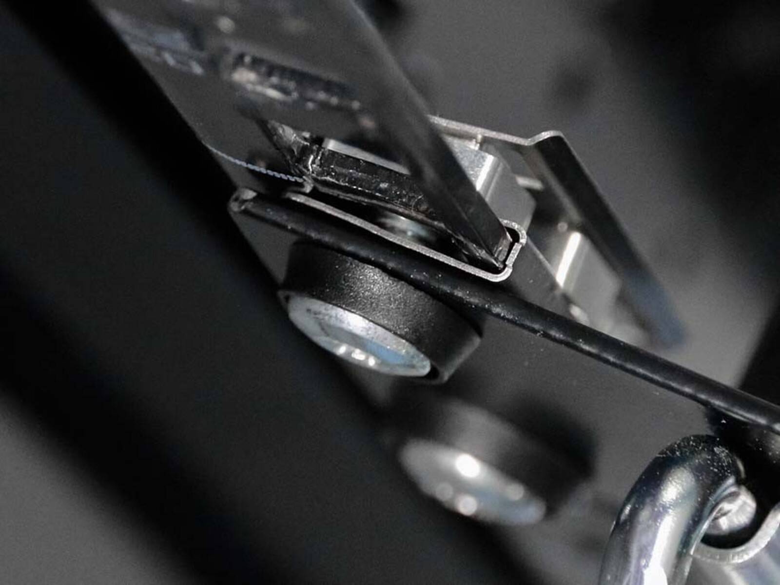 Nahaufnahme eines Metallgetriebes, die präzise Teile und Schrauben zeigt. Der Fokus liegt auf den detaillierten Komponenten und deren Zusammenbau.