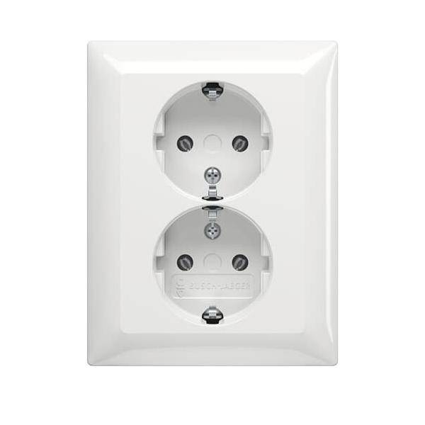 Eine weiße doppelte elektrische Steckdose mit zwei runden Steckplätzen ist an einer Wand montiert.