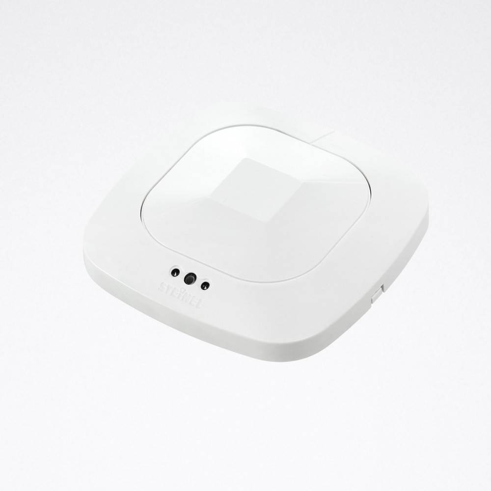 Ein weißes Wireless-Zugangspunkt-Gerät mit drei kreisförmigen Anzeigen auf seiner Oberfläche, vor einem einfarbigen Hintergrund.
